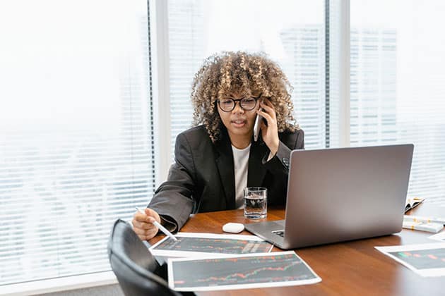 Image of woman at desk with laptop reviewing crypto stocks