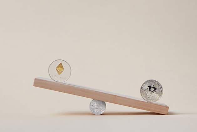 Image of ethereum and bitcoin on a wooden scale
