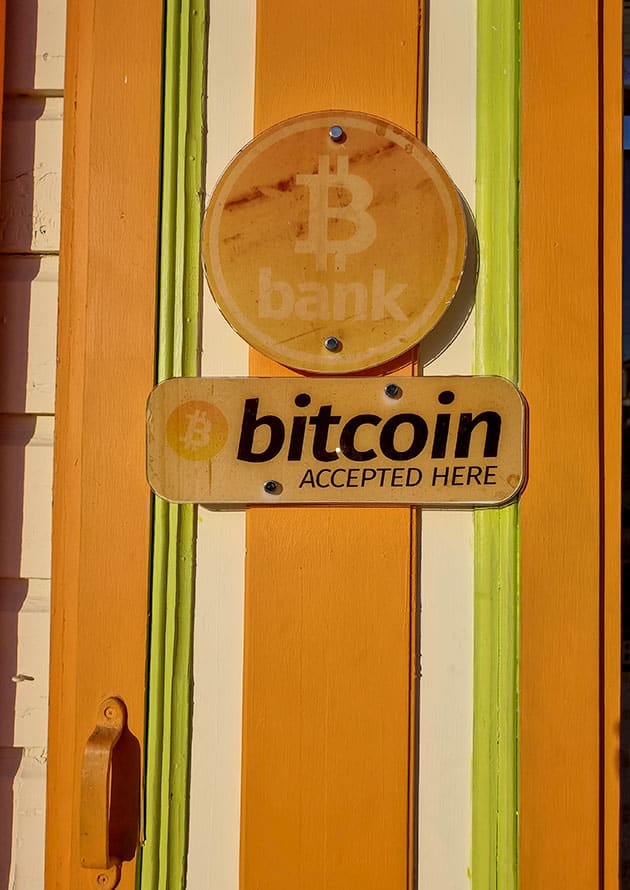 Image of bitcoin bank with sign that says “bitcoin accepted here”