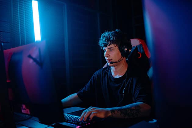 Picture of teenager with headset playing video game