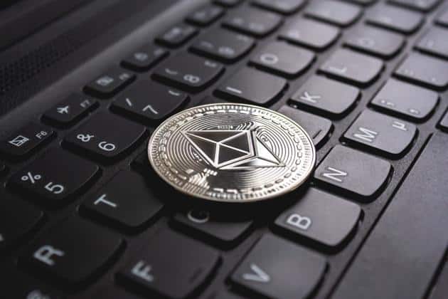 Etherium coin placed on top of a black computer keyboard